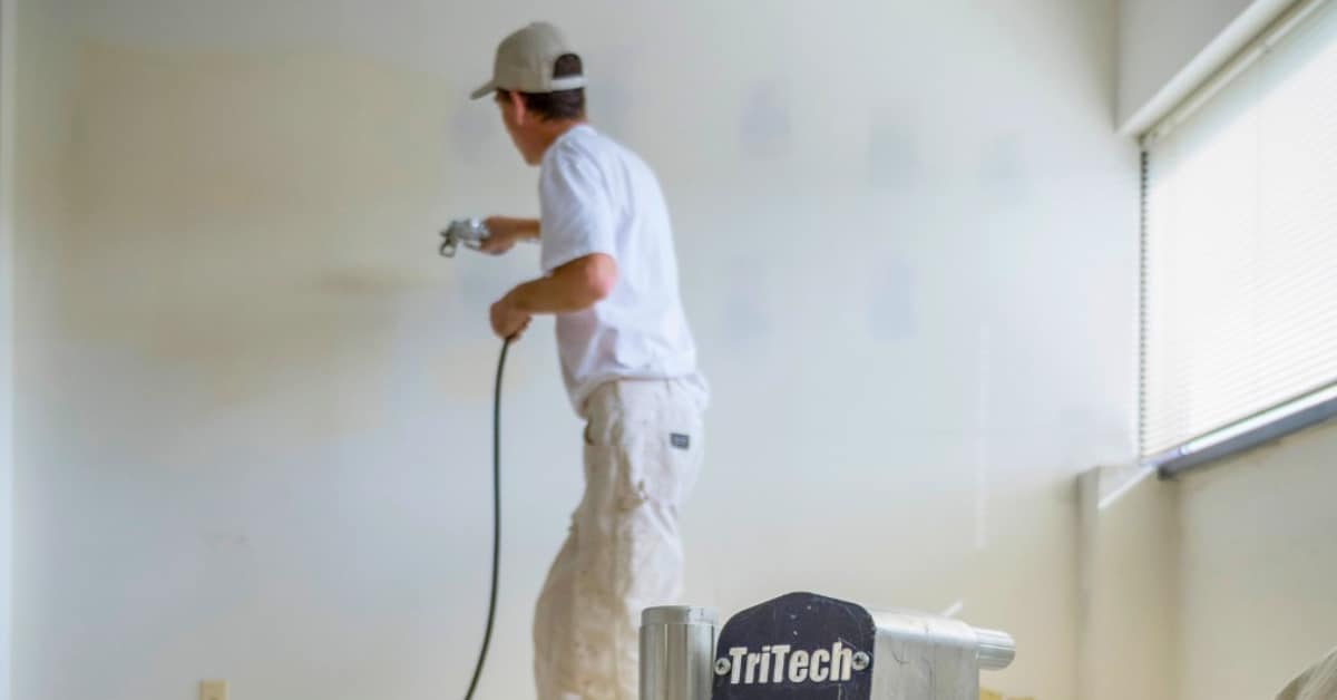 man painting with an airless paint spray gun